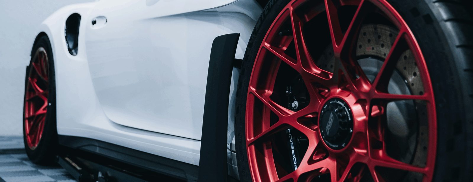 White Porsche with red forged wheels in the Max PPF & Detailing studio