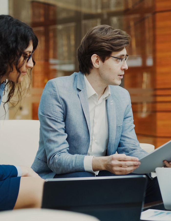 Two colleagues reviewing work together in a bright office